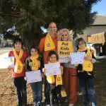 homeschool family holding placards on grass